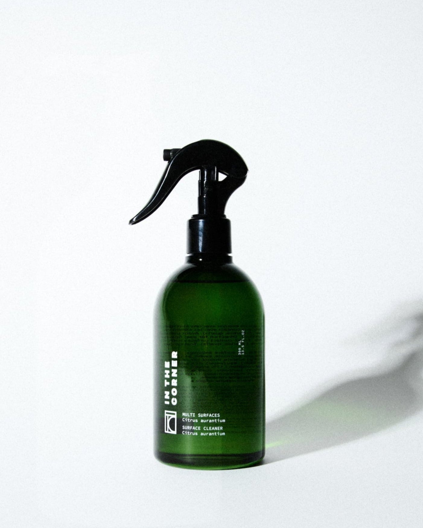 Produit nettoyant multisurfaces au parfum signature Citrus Aurantium pour votre cuisine et salle de bain, dans une jolie bouteille en verre verte, présentée sur un fond blanc