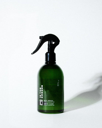 Produit nettoyant multisurfaces au parfum signature Citrus Aurantium pour votre cuisine et salle de bain, dans une jolie bouteille en verre verte, présentée sur un fond blanc